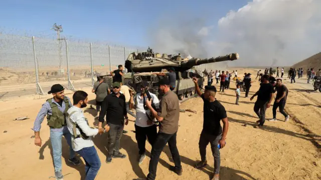 ইসরায়েলের একটি ট্যাংক ঘিরে আছে হামাসের একটি সশস্ত্র শাখার সদস্যরা।