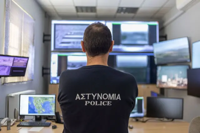 Un policía griego mira unos monitores.