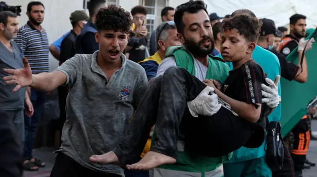 Un hombre lleva a un niño herido al hospital al-Shifa tras los ataques israelíes en la ciudad de Gaza el 10 de octubre de 2023