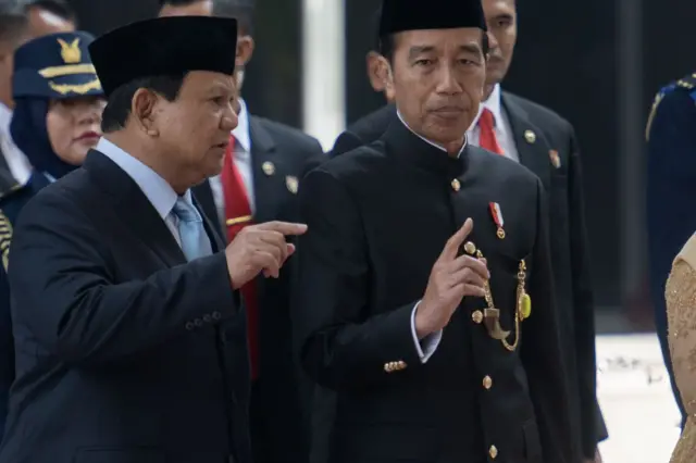 Joko Widodo (kanan) berbincang dengan Presiden terpilih Prabowo Subianto (kiri) saat meninggalkan gedung DPR di Jakarta.