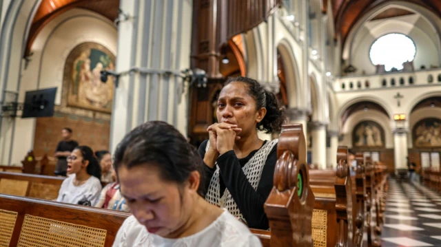 Seorang perempuan menangis saat berdoa di Gereja Katedral Jakarta, 21 April 2025.