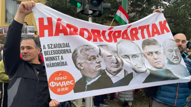 Противники Орбана с плакатом, на котором он сам, Путин, Трамп
