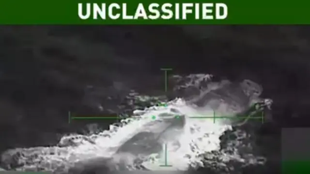 白黒の画像に潜水艇らしき黒っぽい物体と、波とみられる白いものが写っている。画像上部には「機密扱いではない」という文字が表示されている