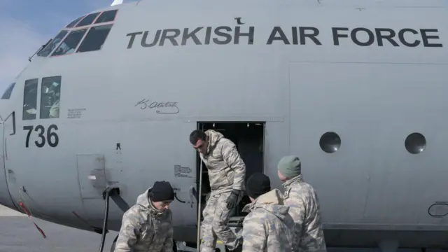Üzerinde İngilizce "Türk Hava Kuvvetleri" yazan bir uçak, kapısından askerler iniyor.