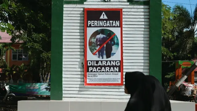 Dua anak perempuan berjalan di depan psoter dilarang pacaran