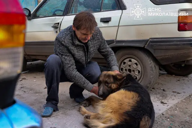 Чоловік заспокоює собаку 