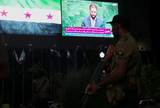 أحد أفراد قوات الأمن السورية في حلب خلال عرض خطاب رئيس المرحلة الانتقالية في سوريا أحمد الشرع في اجتماع الجمعية العامة للأمم المتحدة