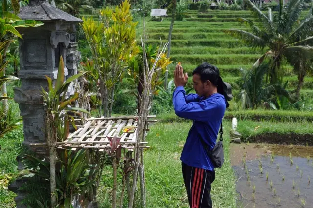 Petani berdoa sebelum menerbangkan drone untuk pemupukan sawah di Desa Jatiluwih, Kabupaten Tabanan, Bali.