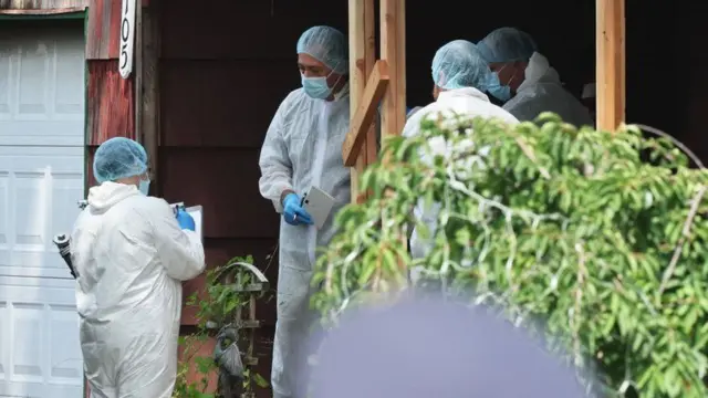 Investigadores en la puerta de la casa del sospechoso