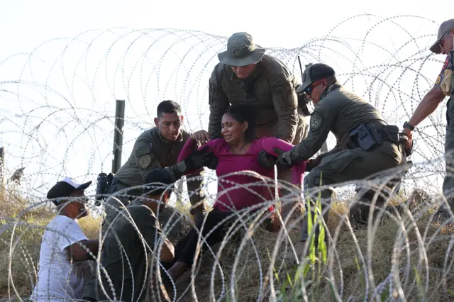 Policías estatales de Texas ayudan a los migrantes a través de alambre de concertina a lo largo del río Grande en Eagle Pass, Texas, EE.UU., 01 de agosto de 2023. Foto de ADAM DAVIS/EPA-EFE/REX/Shutterstock 