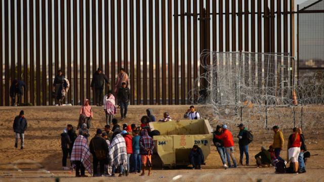 Imigrantes em muro nos EUA