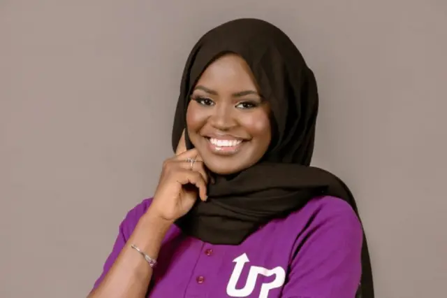 Portrait de la coach Mariama Ndiaye. Elle porte un T-shirt mauve et un voile noir. 