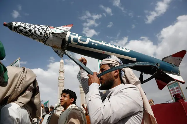 صورة أرشيفية لمتظاهر يمني يلوح بصاروخ وهمي خلال مظاهرة داعمة لإيران وفلسطين في العاصمة اليمنية صنعاء.