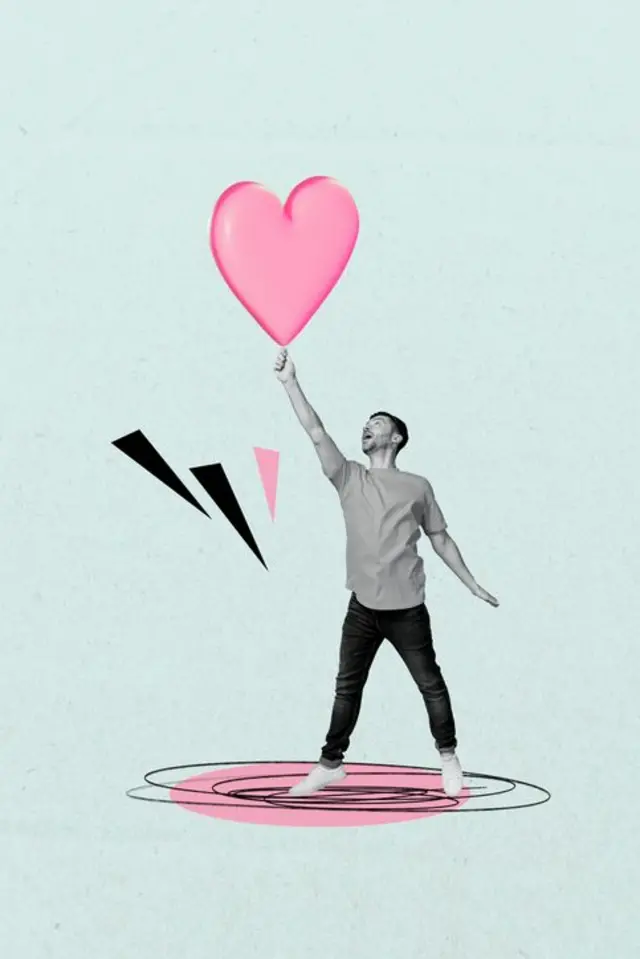 Bir adam elinde kalp çizimi tutuyor. 