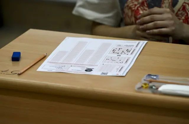 Sıranın üzerinde kurşun kalem ile bir kısmı işaretlenmiş bir cevap anahtarı, kurşun kalem ve silgi bulunuyor.