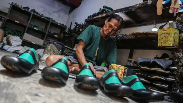 Pekerja menyelesaikan pembuatan alas kaki sandal kulit di rumah industri sepatu, Rejomulyo, Semarang, Jawa Tengah, Selasa (6/1/2026). 