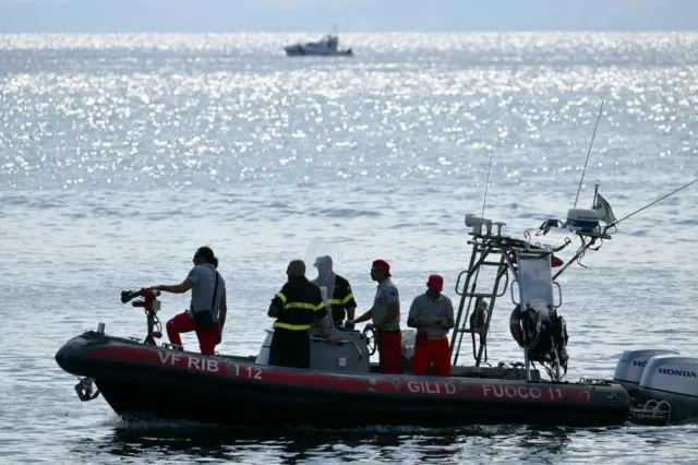 Buzos buscando personas bajo la superficie del mar cerca de Sicilia