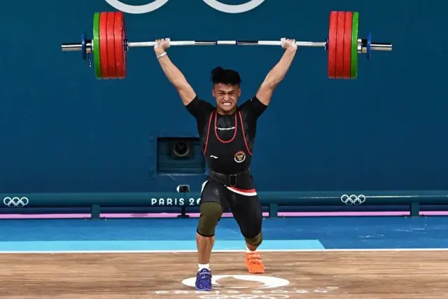 Lifter Indonesia Rizki Juniansyah melakukan angkatan clean and jerk dalam kelas 73 kg putra Olimpiade Paris 2024 di South Paris Arena, Paris, Prancis, Kamis (8/8/2024).