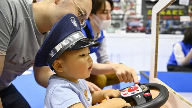 Niño jugando con un autito junto a su padre