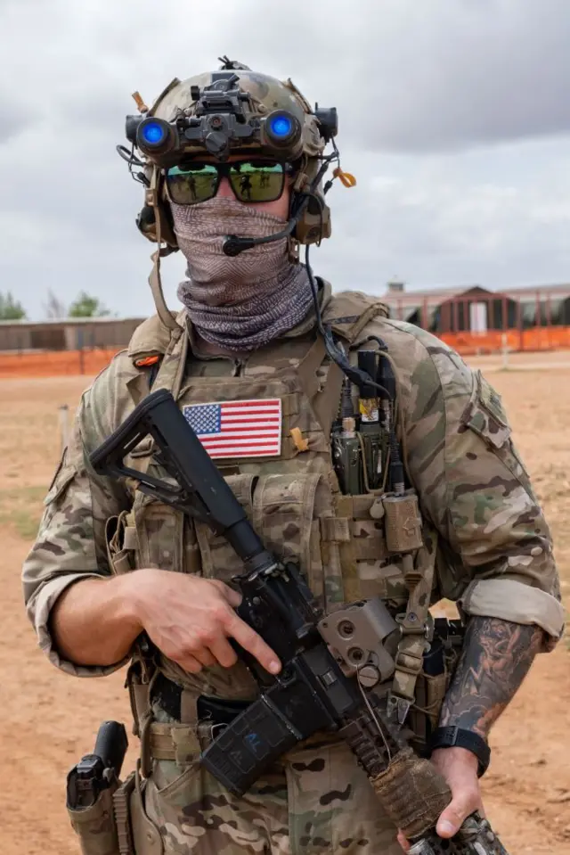 Un soldat américain en uniforme pose avec un fusil d'assaut