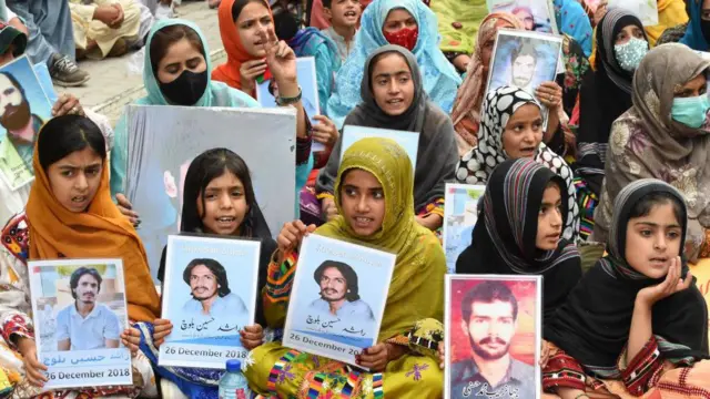 बलूचिस्तान में लापता लोगों की तस्वीर के साथ नागरिक अधिकारों के लिए प्रदर्शन करते स्थानीय लोग