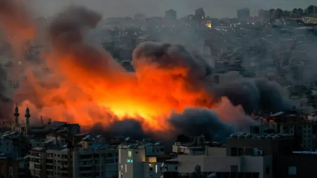ビルが並ぶ薄暗い市街地にオレンジ色の巨大な爆発が起き、黒煙が上っている