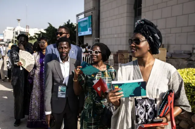Les invités à la Biennale de Dakar, exposition d'art contemporain africain « The Wake » font la queue avant la cérémonie d'ouverture à Dakar le 7 novembre 2024