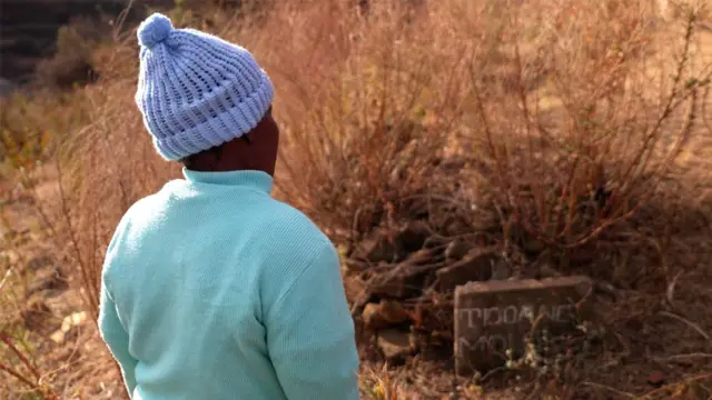 La señora Moloi junto a la tumba de su hijo, Tlohang.