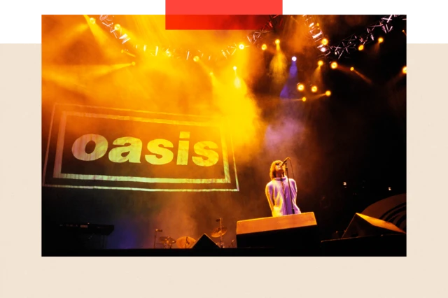 Liam Gallagher in a white coat singing in front of the Oasis logo