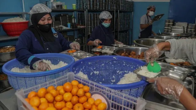 Sejumlah petugas mengisi makanan ke dalam ompreng Makan Bergizi Gratis (MBG) di dapur SPPG Tubo Ternate, Maluku Utara, Senin (26/1/2026).