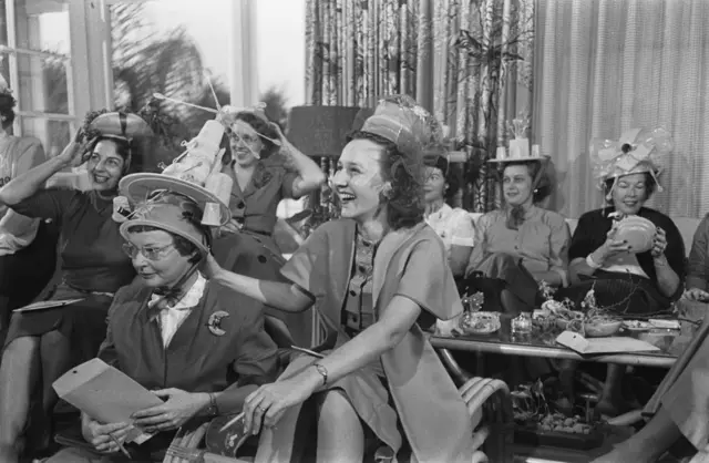 Sekelompok perempuan menghadiri pesta Tupperware, beberapa memakai topi yang dibuat dari produk Tupperware pada 1955.