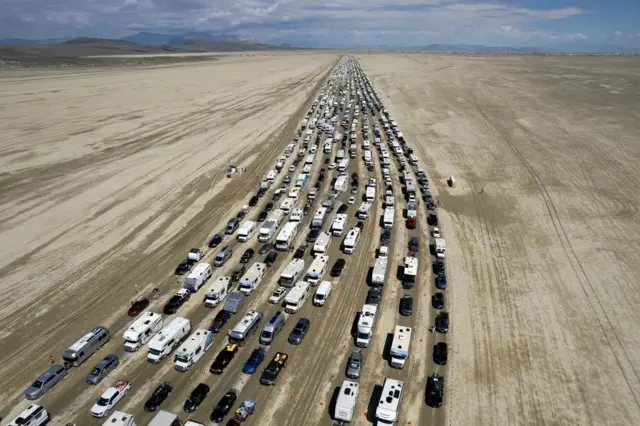 Mobil-mobil mencoba meninggalkan festival Burning Man.