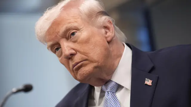 特朗普在白宮主持新聞發佈會,他頭擰向左側凝視著媒體記者(6/4/2026)