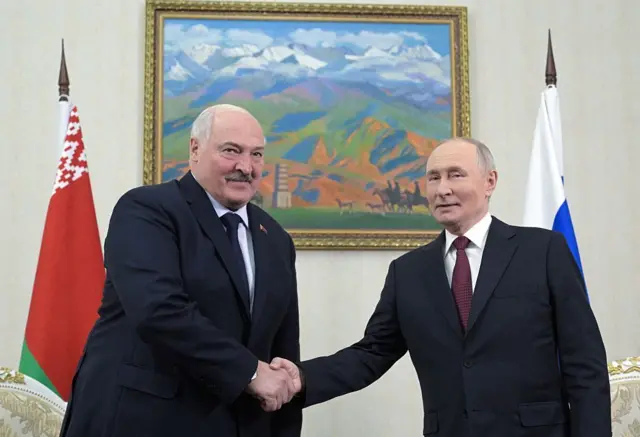 Alexandr Łukaszenka and Vladimir Putin shaking hands.
