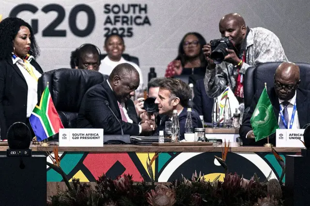 
Perezida w’Ubufaransa Emmanuel Macron, yunamye, asuhuza Perezida wa Afurika y’Epfo Cyril Ramaphosa mbere yo kuva muri Afurika y’Epfo, ku munsi wa kabiri w’inama y’abayobozi ba G20, ku ya 23 Ugushyingo 2025 i Johannesburg, muri Afurika y’Epfo.