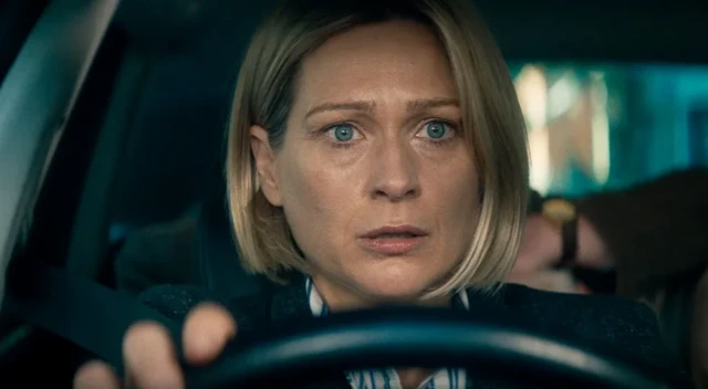 Una mujer al volante, con expresión de estar impresionada. 