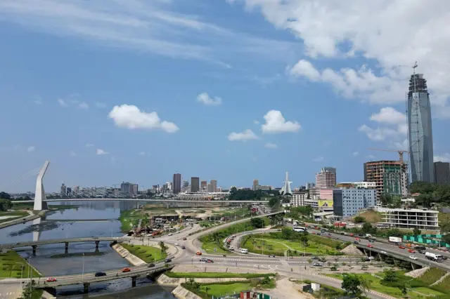 Une vue de la capitale ivoirienne avec la lagune Ebrié, des ponts, des routes et des bâtiments.