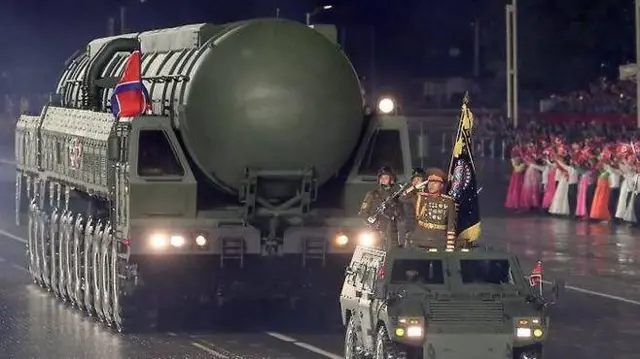 발사관에 담긴 신형 ICBM 추정 '화성-20형'과 그 앞에 전차에 탑승해 경례하고 있는 군인들