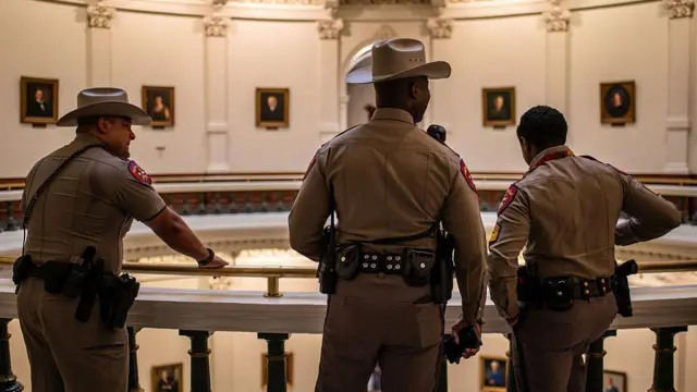 Tres agentes del Departamento de Seguridad de Texas, de espaldas en el Capitolio estatal. 