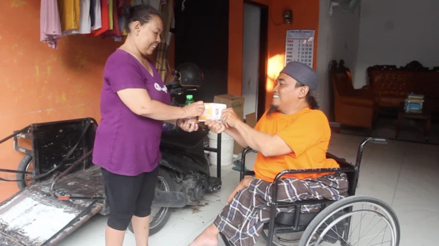 Slamet membagikan sabun cair buatannya kepada warga.