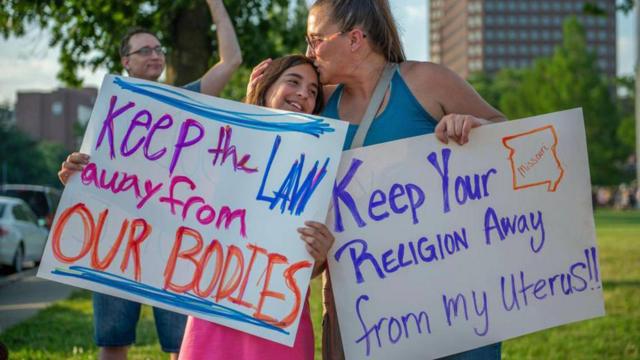 Giuliana Cangelosi, de onze anos, à esquerda, e sua mãe Nichole Cangelosi compartilham um momento juntas enquanto participam de um protesto contra a decisão da Suprema Corte que anula as proteções federais ao direito ao aborto em 24 de junho de 2022, em Mill Creek Park, no Country Club Plaza