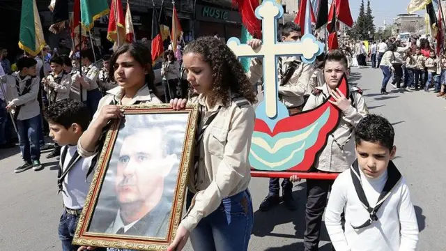 Umat ​​Kristen Ortodoks Suriah membawa potret Presiden Bashar al-Assad selama prosesi Minggu Palma pada tanggal 5 April 2015 di ibu kota Suriah, Damaskus.