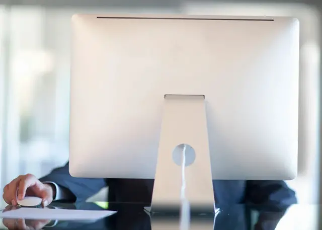 Un homme derrière un ordinateur Mac