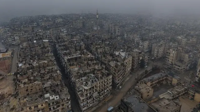 Çatışmalar sonrası Halep'teki Şeyh Maksud mahallesinin havadan çekilen görüntüsünde harabeye dönmüş binalar görülüyor. 