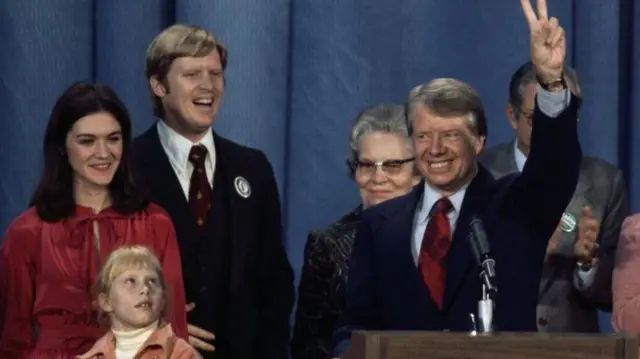 జిమ్మీ కార్టర్, అతని కుటుంబ సభ్యులతో చుట్టుముట్టబడి, 1976 అధ్యక్ష ఎన్నికలలో విజయాన్ని జరుపుకుంటున్నారు