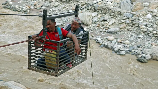 पहिरोका कारन पुलमा क्षति पुगेपछि मानिसहरू फुङ्लिङमा तुइन तर्न बाध्य भएका छन् 