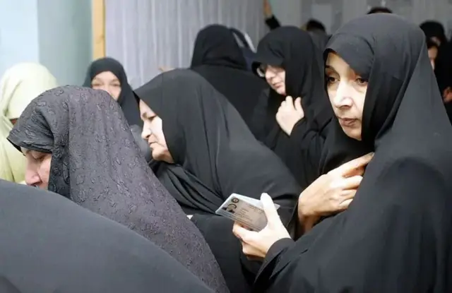 تعدادی زن با چادر مشکی در صف انتخابات و رای دادن