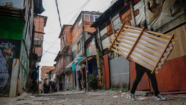 Un hombre carga una caja en una favela de Brasil.