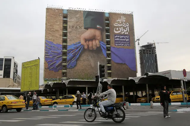 Теҳрондаги девор суратида Ҳўрмузни жиловлаб турган эронлик қўл акс этган