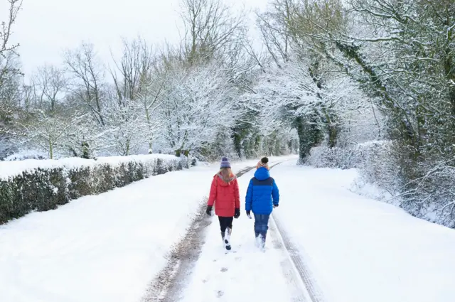 Karda yürüyen iki kişi